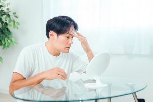 鏡を見る男性