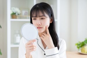 鏡で顔を見る女性