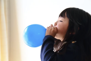 風船を膨らます子ども